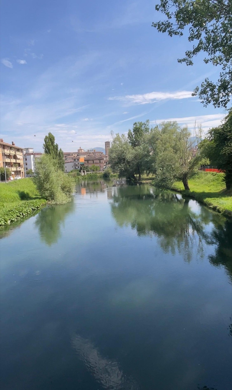 A river running past a town under a summer sky
